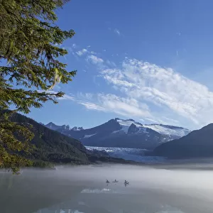 Three Kayakers Paddle The Shoreline Of Mendenhall Lake As Morning Fog Clears, Tongass National Forest, Juneau, Alaska