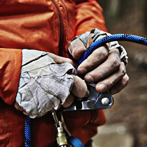 Man Adjusting Rock Climbing Equipment In The Adirondacks; New York, USA