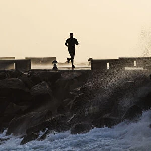 Silhouette Of A Man Running Along The Coast; La Isla, Tarifa, Cadiz, Andalusia, Spain