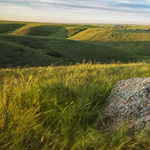 Sunset Over The Coulees And Buttes Of Grasslands National Park With Erratic In Foreground; Saskatchewan, Canada