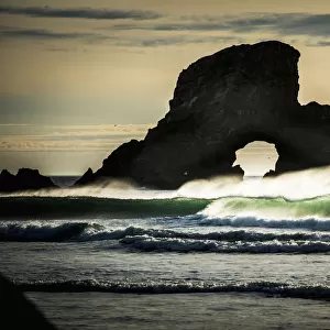 Surf Breaks Near A Natural Arch; Cannon Beach, Oregon, United States Of America