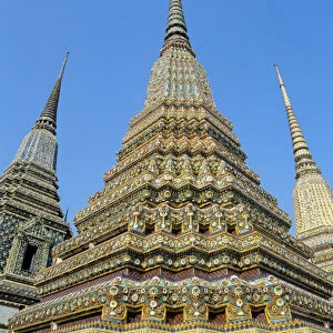 Thailand, Bangkok, Colorful Pointed Steeples Against Clear Blue Sky; Wat Po