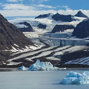 View of a tidewater glacier and snowy mountains
