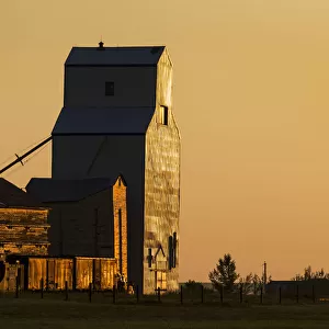Wooden Grain Elevator Refecting The Orange Glow Of Sunrise; Mossleigh, Alberta, Canada