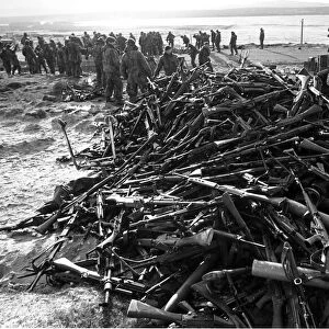 ARGENTINE SOLDIERS SURRENDER RIFLES EN ROUTE FROM STANLEY TO THE AIRPORT AT THE END OF