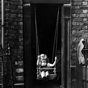 A child playing in a doorway at Netherfield Road, Liverpool. 24th July 1964