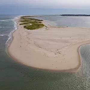 The cold water of the Atlantic Ocean washes onto a beautiful sandy beach on Cape Cod, Massachusetts. This scenic peninsula is a popular vacation area