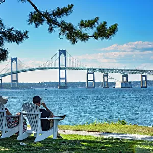Rhode Island, Newport, People relaxing on Goat Island with view of Claiborne Pell Bridge