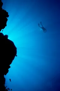 Micronesia, Yap, Light Rays Shining Through Reef Canyon, Diver In Distance Micronesia, Yap, Light Rays Shining Through Reef Canyon, Diver In Distance