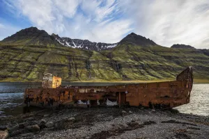 Old Shipwreck Along The Water In Mjoifjordur, East Iceland; Iceland Old Shipwreck Along The Water In Mjoifjordur, East Iceland; Iceland