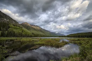 Reflection of mountains and sky in tranquil water at dusk, Yukon, Canada Reflection of mountains and sky in tranquil water at dusk, Yukon, Canada