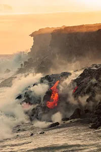 Sea Water And Molten Rock Splatter Together As A Wave Crashes Onto The Pahoehoe Lava Sea Water And Molten Rock Splatter Together As A Wave Crashes Onto The Pahoehoe Lava