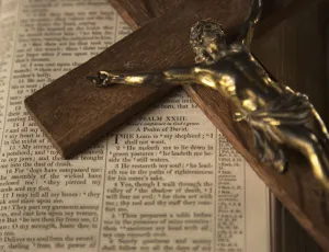 Wooden crucifix laying on open Bible; Yetholm, Scottish Borders, Scotland, UK Wooden crucifix laying on open Bible; Yetholm, Scottish Borders, Scotland, UK